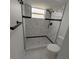 Updated bathroom with marble shower and gray floor tile at 2048 Tumbleweed Dr, Holiday, FL 34690