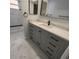 Modern bathroom with gray vanity, quartz countertop, and marble tile at 2048 Tumbleweed Dr, Holiday, FL 34690