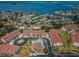 Aerial of condo community featuring bay views, pool, and manicured grounds at 2353 Hanover Dr, Dunedin, FL 34698