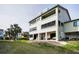 Back of condo featuring patio area with seating overlooking lawn and palm trees at 2353 Hanover Dr, Dunedin, FL 34698