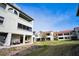 Condo backyard with patio and seating, set within a community lawn and landscaping at 2353 Hanover Dr, Dunedin, FL 34698