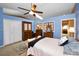 Bright and airy bedroom with blue walls, a ceiling fan, and a view into another room at 2353 Hanover Dr, Dunedin, FL 34698