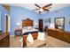 Large bedroom with blue walls, a ceiling fan, and lots of wooden furniture at 2353 Hanover Dr, Dunedin, FL 34698