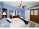 Blue primary bedroom with a ceiling fan, dresser, rocking chair, and ample natural light at 2353 Hanover Dr, Dunedin, FL 34698