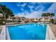 Community pool with lounge chairs surrounded by lush palm trees at 2353 Hanover Dr, Dunedin, FL 34698