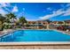 Community pool with lounge chairs and lush tropical landscaping at 2353 Hanover Dr, Dunedin, FL 34698