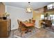 Bright dining room view featuring stylish wooden furniture, laminate flooring, and a decorative light fixture at 2353 Hanover Dr, Dunedin, FL 34698