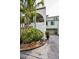 Charming two-story condo with stucco siding, an attached garage, and lush tropical landscaping at 2353 Hanover Dr, Dunedin, FL 34698