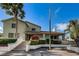 Exterior of condo with stairs leading to entrance, featuring mature trees and landscaping at 2353 Hanover Dr, Dunedin, FL 34698