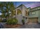 Charming two-story condo with stucco siding, an attached garage, and lush tropical landscaping at 2353 Hanover Dr, Dunedin, FL 34698