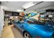 Organized garage with a blue Corvette parked inside, featuring ample storage and a kayak at 2353 Hanover Dr, Dunedin, FL 34698