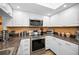 Bright kitchen features stainless steel appliances, white cabinets, and ample counter space, offering a functional cooking area at 2353 Hanover Dr, Dunedin, FL 34698