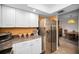 Well-appointed kitchen showcasing stainless steel refrigerator and ample counter space, flowing into the adjacent dining area at 2353 Hanover Dr, Dunedin, FL 34698