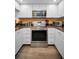 Updated kitchen boasts stainless steel appliances and sleek white cabinetry, offering a modern and efficient cooking space at 2353 Hanover Dr, Dunedin, FL 34698