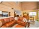 Spacious living room features vaulted ceilings and a large leather sectional sofa, creating a warm and inviting atmosphere at 2353 Hanover Dr, Dunedin, FL 34698
