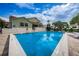 Community pool surrounded by palm trees and lounge chairs on a sunny day at 2353 Hanover Dr, Dunedin, FL 34698