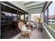 Screened in porch with rocking wicker chairs, pillows and outdoor view at 2353 Hanover Dr, Dunedin, FL 34698