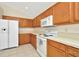 View of kitchen with white appliances and wood cabinets at 2908 Billingham Dr, Land O Lakes, FL 34639