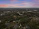 Wide aerial view of home, community, and surrounding area at dusk at 291 Winchester Way, Palm Harbor, FL 34684