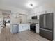 Modern kitchen with white cabinets, stainless steel appliances, and a large island at 291 Winchester Way, Palm Harbor, FL 34684
