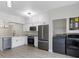 Modern kitchen with white cabinets, stainless steel appliances, and laundry area at 291 Winchester Way, Palm Harbor, FL 34684