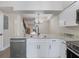 Modern kitchen with white cabinets, stainless steel appliances, and granite countertops at 291 Winchester Way, Palm Harbor, FL 34684