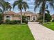 One-story house with tile roof, lush landscaping, and palm trees at 34303 Sahalee Loop, Dade City, FL 33525