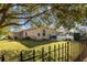 Spacious backyard with a fenced enclosure, lush lawn, and shade tree at 377 Jenico Ct, Spring Hill, FL 34609
