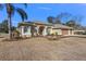House exterior features a three-car garage and manicured lawn at 377 Jenico Ct, Spring Hill, FL 34609