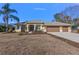 Exterior view of a single-story house with a three-car garage and manicured lawn at 377 Jenico Ct, Spring Hill, FL 34609