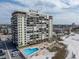 Aerial view of beachfront condo building with pool and parking at 3820 Gulf Blvd # 203, St Pete Beach, FL 33706