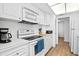 White kitchen features an electric stove and microwave at 3820 Gulf Blvd # 203, St Pete Beach, FL 33706