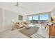 Bright living room featuring neutral tile flooring, comfortable sofa and water views from a private balcony at 400 Island Way # 1404, Clearwater Beach, FL 33767