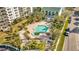 Aerial view of a sparkling pool with palm trees and well-manicured landscaping at 400 Island Way # 1404, Clearwater Beach, FL 33767