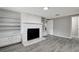 Stone fireplace with built in shelving in a living room with gray walls and gray laminate floors at 40242 Sunburst Dr, Dade City, FL 33525