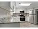 Modern kitchen with white cabinets, stainless steel appliances, and granite countertops at 40242 Sunburst Dr, Dade City, FL 33525