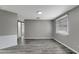 Spacious living room with gray walls, gray laminate floors, and a window with blinds at 40242 Sunburst Dr, Dade City, FL 33525