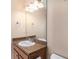 Bathroom featuring a granite-topped vanity with cabinet storage and modern lighting at 5038 White Sanderling Ct, Tampa, FL 33619
