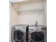 Well-lit laundry room with modern, stainless steel washer and dryer and built-in wire shelving at 5038 White Sanderling Ct, Tampa, FL 33619