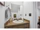 Cozy half bathroom with wood vanity, decorative mirror, and light fixture at 5328 Ridgewell Ct, Tampa, FL 33624