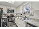 Bright kitchen with stainless steel appliances, granite countertops, and a window view at 5328 Ridgewell Ct, Tampa, FL 33624