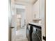 Hallway view of the laundry room that features sleek appliances, storage cabinets, and a convenient folding area at 6205 River Ter, Tampa, FL 33604