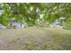 Large backyard with mature trees and spacious grassy area at 723 Ornelda Sw St, Ruskin, FL 33570