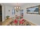 Charming dining room with glass table, red chairs, and chandelier at 723 Ornelda Sw St, Ruskin, FL 33570