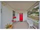 Inviting front porch with red door, white picket fence, and comfortable seating at 723 Ornelda Sw St, Ruskin, FL 33570