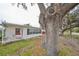 Single story home with white siding, red door, and mature tree at 723 Ornelda Sw St, Ruskin, FL 33570