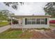 White house with black shutters, carport, and small yard at 723 Ornelda Sw St, Ruskin, FL 33570