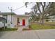 Side entrance with covered porch and red door at 723 Ornelda Sw St, Ruskin, FL 33570