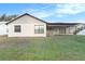 Back of the house featuring a screened porch and a well-maintained lawn at 8504 Yearling Ln, New Port Richey, FL 34653