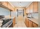 Galley kitchen with wood cabinets and appliances at 9119 Tudor Dr # E201, Tampa, FL 33615